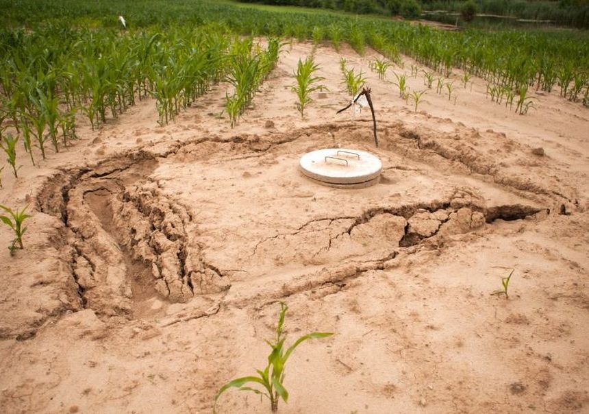 Terreno hundido y agrietado alrededor del registro de una fosa séptica en una finca