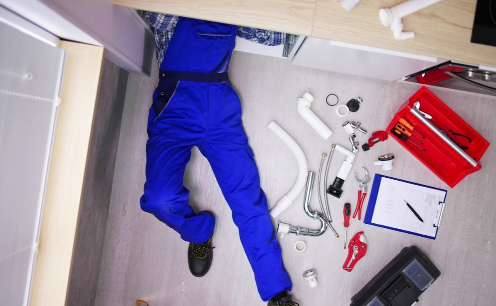 Técnico revisando tuberías para localizar una fuga de agua en una vivienda de A Coruña
