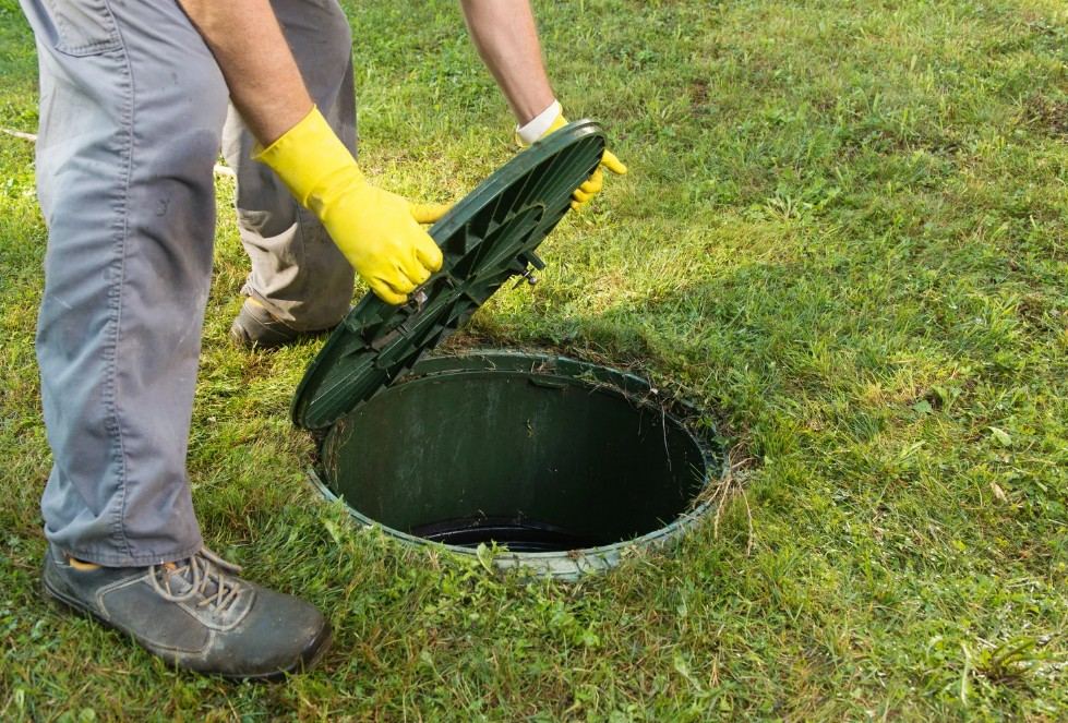 Técnico abriendo la tapa de una fosa séptica para su mantenimiento preventivo